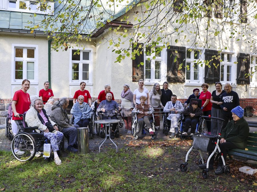 Mieszkańcy i personel spędzają czas razem przed budynkiem Rezydencji