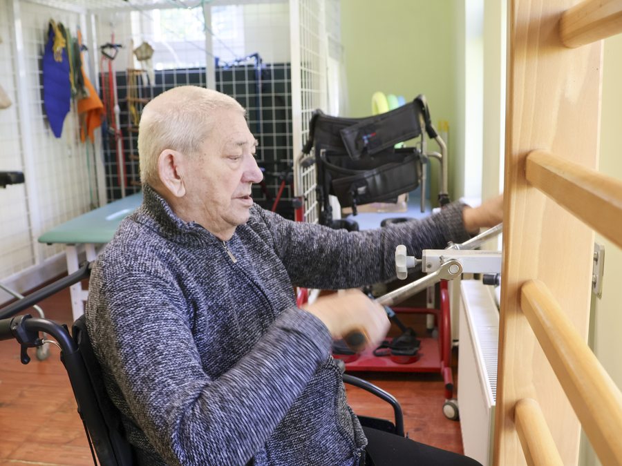 Senior ćwiczy przy sprzęcie do rehabilitacji w Dąbrówce Wielkiej