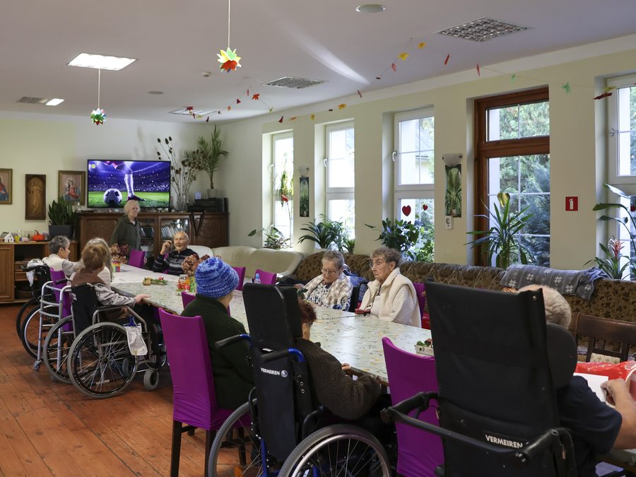 Mieszkańcy wspólnie spędzają czas w jasnej sali dziennej