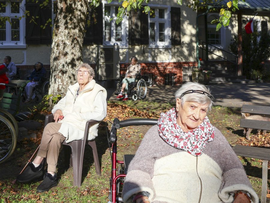 Seniorki odpoczywające w zacienionym parku przed Rezydencją